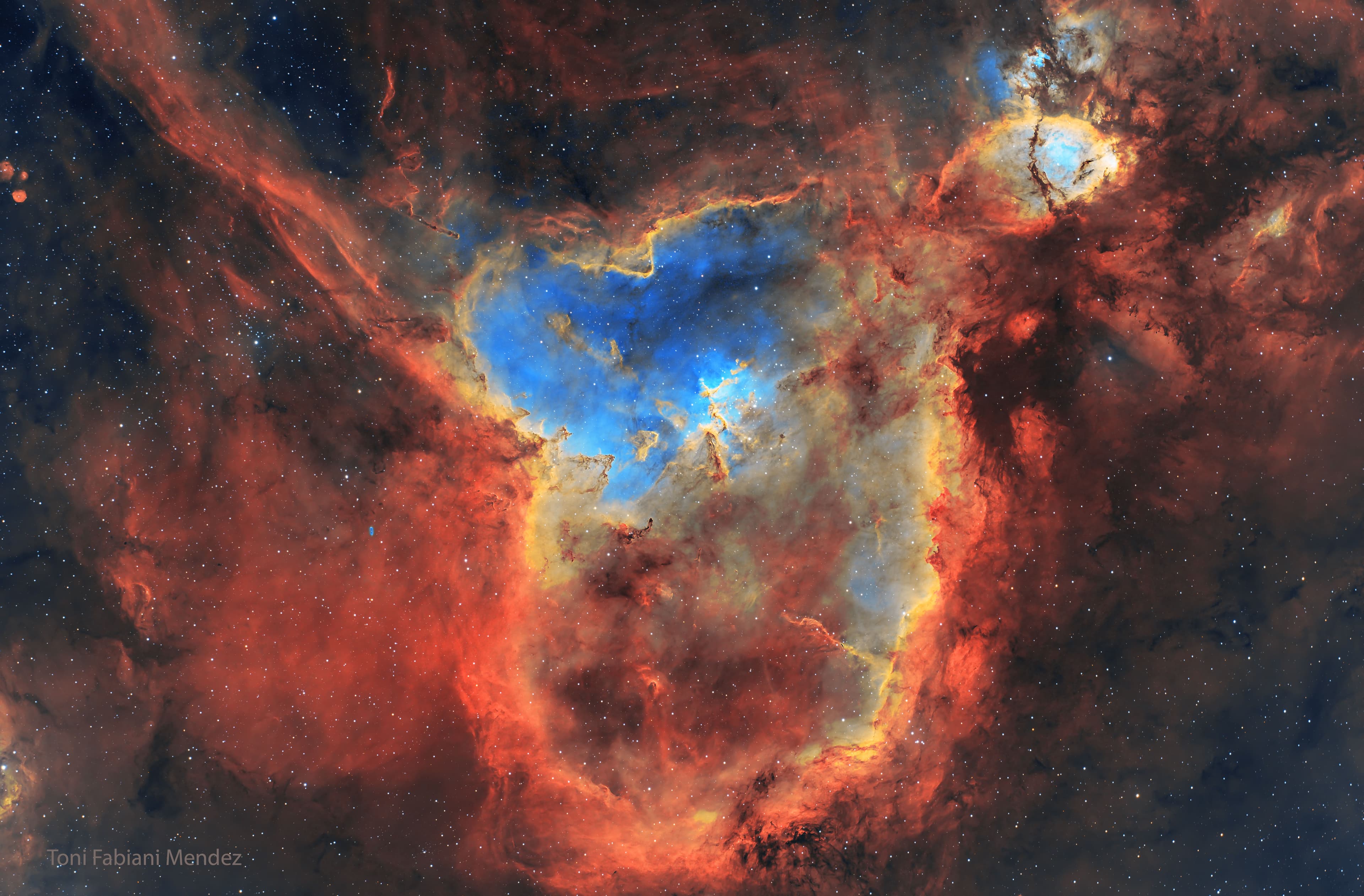 حقل نجومٍ ذاخرٌ بغازٍ ملوّن يتوهّج بألوانٍ مختلفة، وغبارٍ داكن.