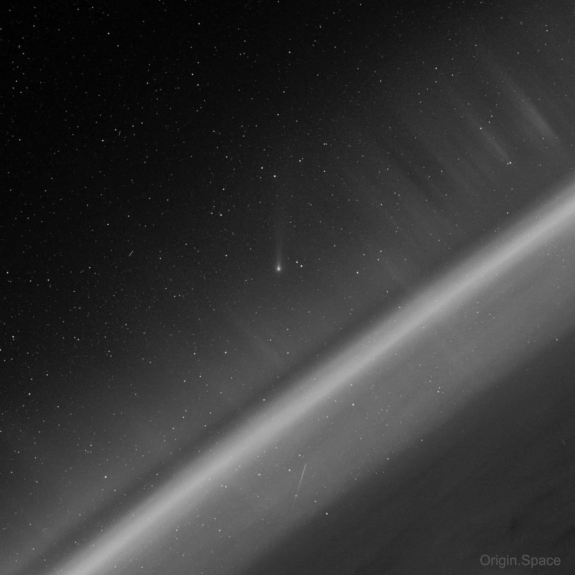 صورة تظهر بدرجات الرمادي يظهر فيها خطّ قطري هو التوهّج الهوائي لطبقات الغلاف الحوّي وفوقه يظهر مذنّب في البعيد بينما تقطعه أشفاق قطبية ويخطّ تحت شهاب. يظهر أثرا تابعين صناعيين كذلك أعلى اليسار