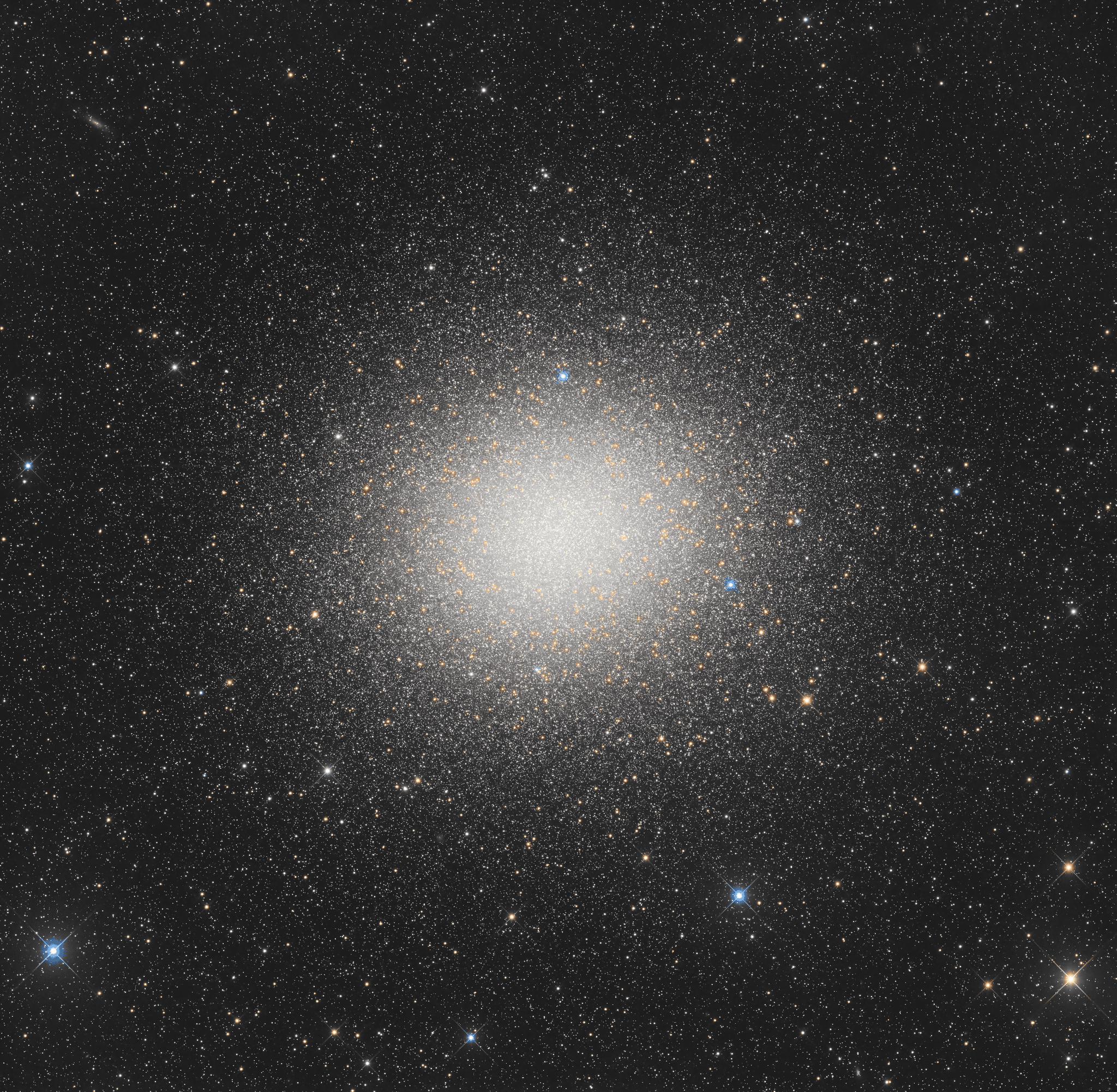 عنقود نجمي كروي مكتظّ بالنجوم الصفراء والبيضاء والزرقاء التي تتواجد في تركيزها الأقصى في المنتصف وتنتشر باتّجاه الخارج، مع ظهور بعض النجوم المنفردة الأقرب أمامه بأشواك حيود.