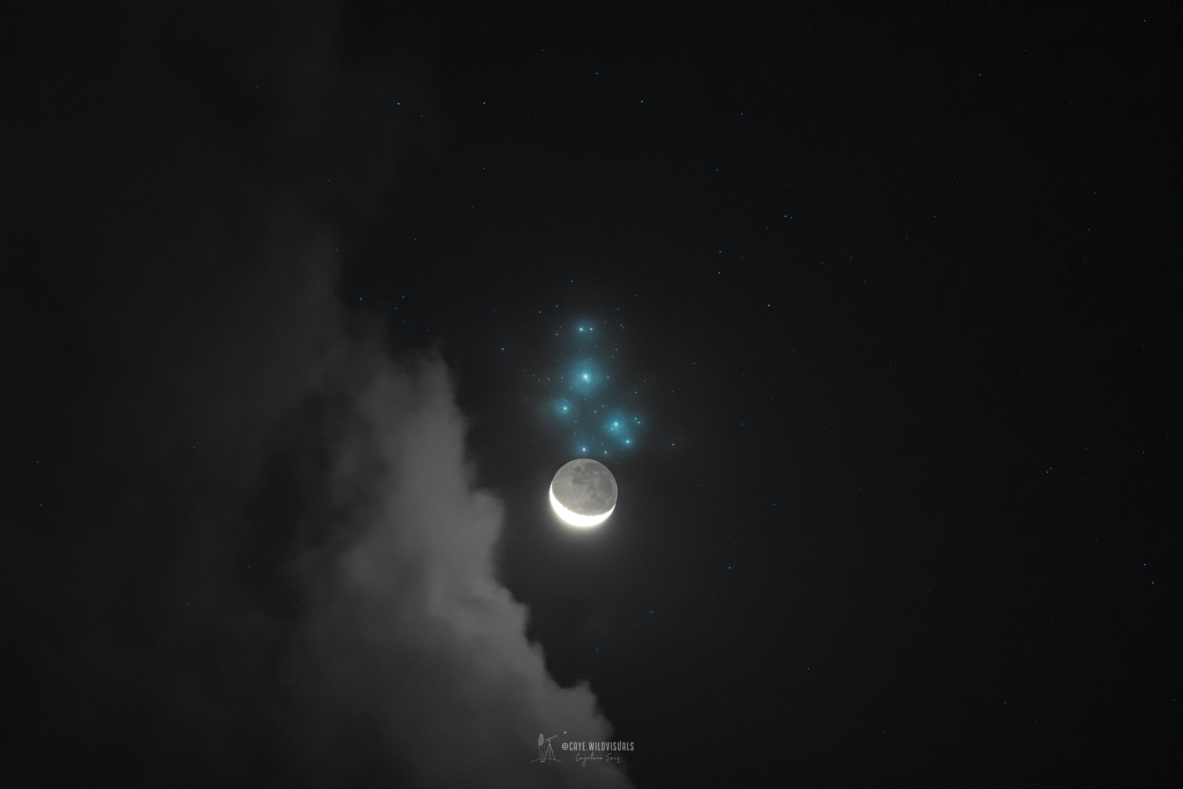 تظهر سماء ليلٍ مُظلِمة فيها سُحُبٌ يساراً. يوجد فوق المركز مباشرةً بالأزرق عنقود نجوم الثُّريّا، وأسفل الثُّريّا مباشرةً يوجد قمرٌ هلال، لكنّه ساطعٌ بما يكفي لدرجة لا تمكّنك من رؤية الهلال المُنار بسطوع فحسب، بل بقيّة القمر أيضاً على نحوٍ أكثر خفوتاً.