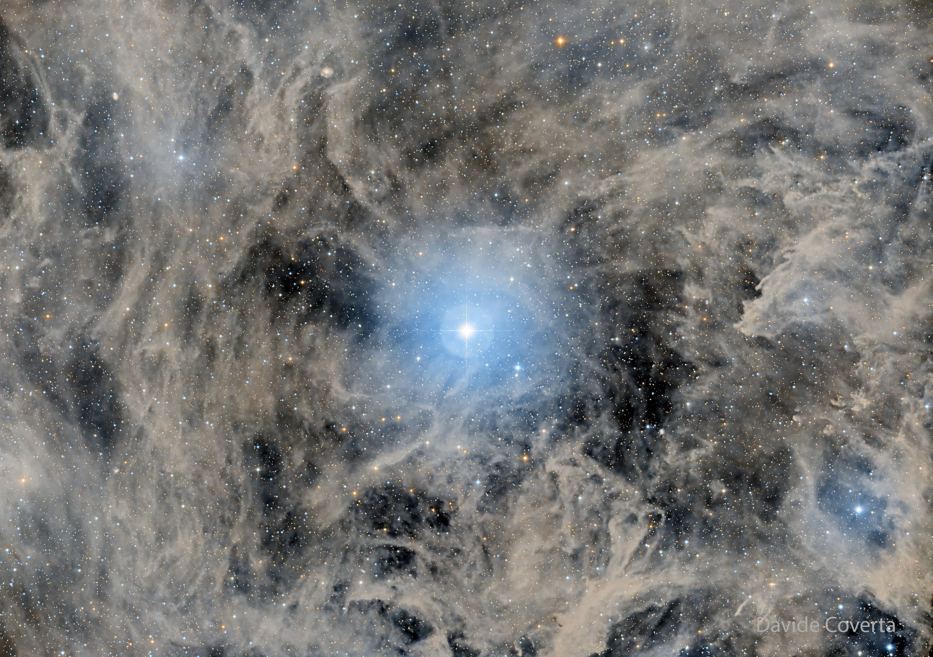 نجم ساطع في مركز الإطار الذي يملؤه الغبار والغاز الساطع ونجومٌ أُخرى أخفت.